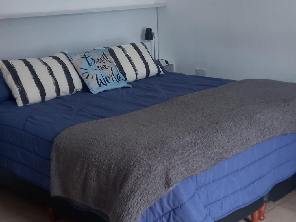uma cama azul com duas almofadas em cima em -BLA BLA... em Ushuaia