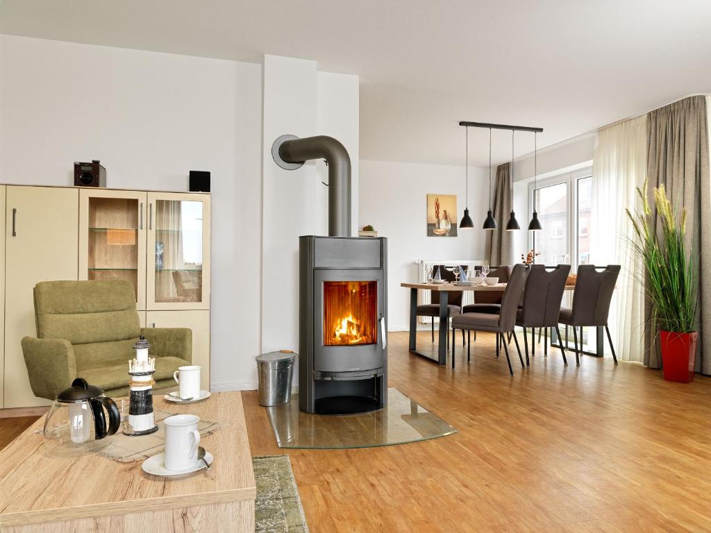 a living room with a fireplace and a dining room at Haus Südwester Austernperle in Timmendorf