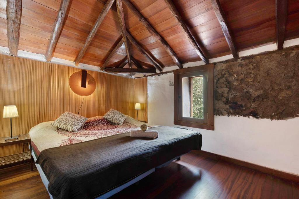 ein Schlafzimmer mit einem großen Bett in einem Zimmer mit Holzdecken in der Unterkunft Hesperia in Icod de los Vinos