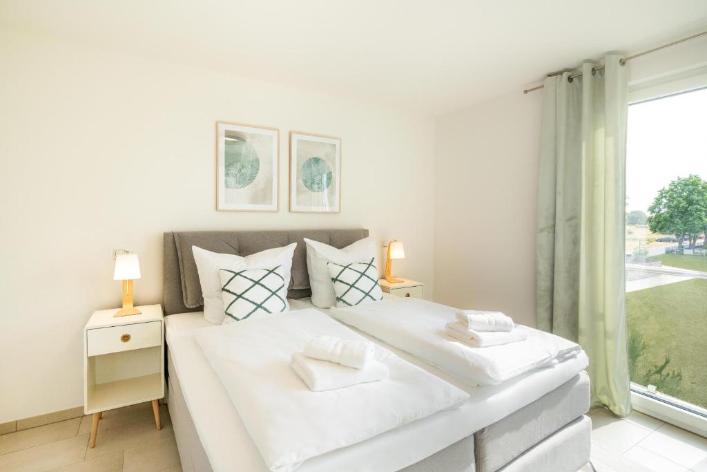 Un dormitorio blanco con una cama grande y una ventana en Apartment "Sonnenlaune" en Garz-Usedom
