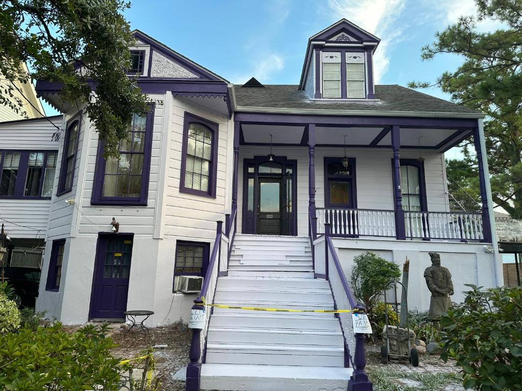 a white house with a blue door and stairs at Oakview Bed and Breakfast in New Orleans