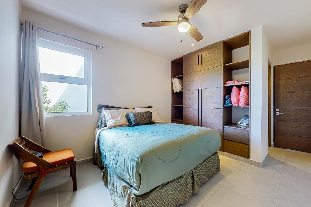 a bedroom with a bed and a window and a chair at Rainbow Fish Hideaway @ TAO Santamar E201 in Akumal