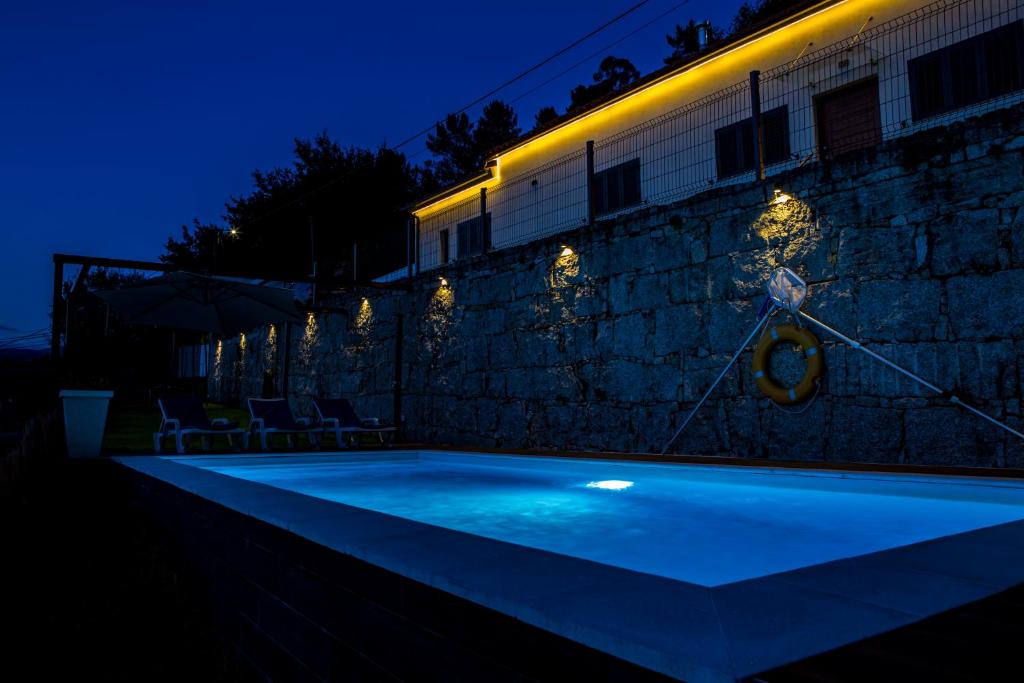 una piscina frente a un edificio por la noche en Toural House, en Arcos de Valdevez