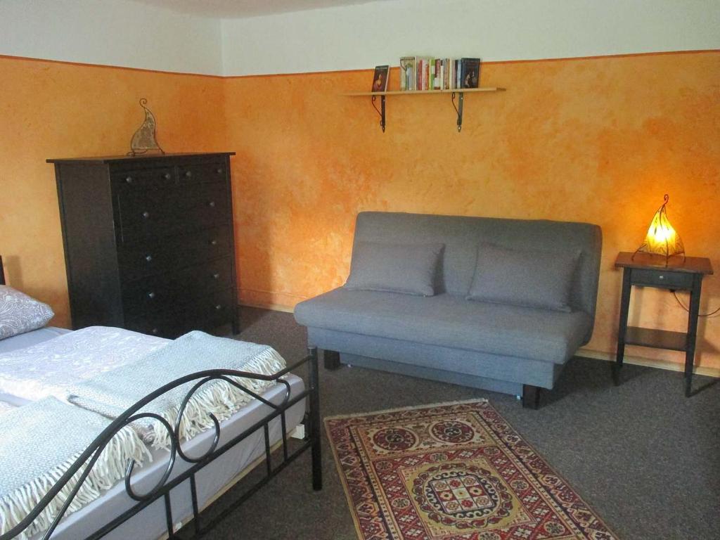 una camera con un letto, un divano e un tappeto di Ferienwohnung im grünen Elbtal a Stadt Wehlen