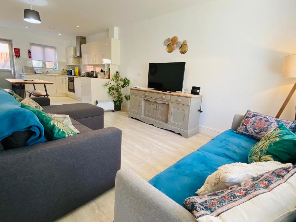 ein Wohnzimmer mit 2 Sofas und einem TV in der Unterkunft Olympic Village Vela - Portland in Portland