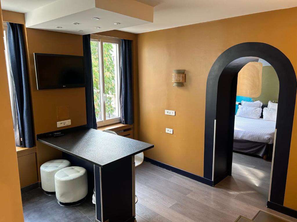 une pièce avec une chambre avec un lit et un bureau dans l'établissement Appartement Censier Daubenton, à Paris