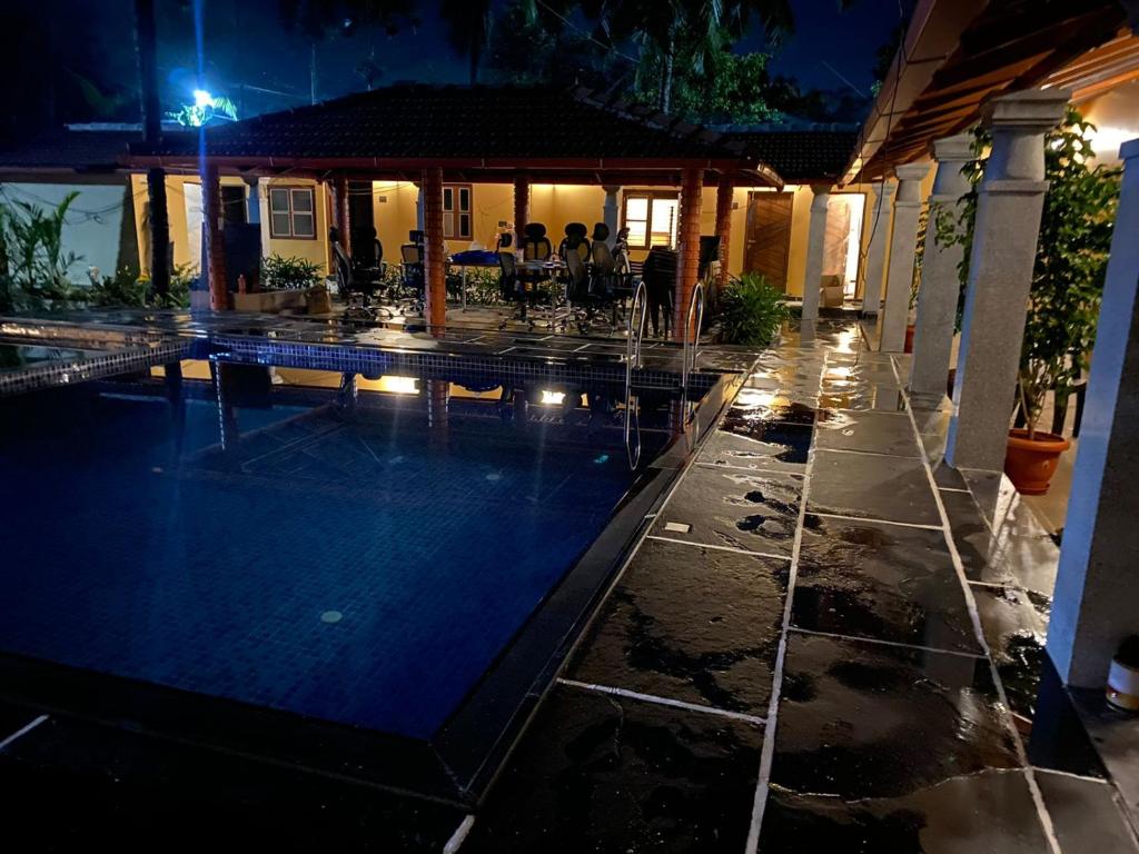 una casa con piscina por la noche en Ooru, en Udupi