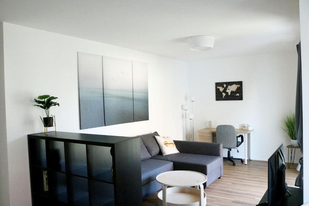 een woonkamer met een bank en een tafel bij Work & Stay Apartment Ingolstadt in Ingolstadt