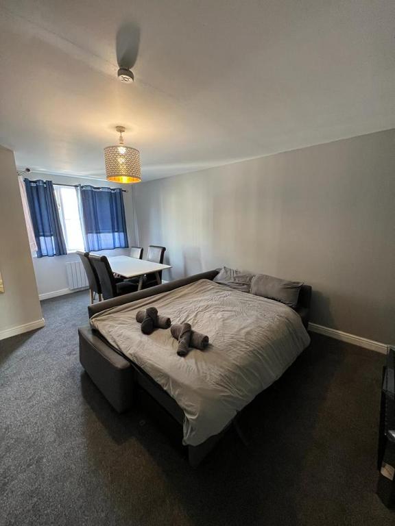 een slaapkamer met een bed met een teddybeer erop bij Cozy 2 Bed Flat in Cricklewood in Londen