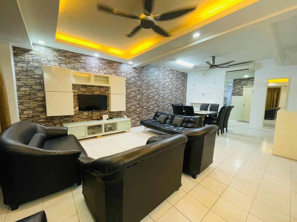 sala de estar con muebles de cuero y pared de piedra. en FREE Wi-fi 100mbps I Emerald Cove Rawang en Rawang