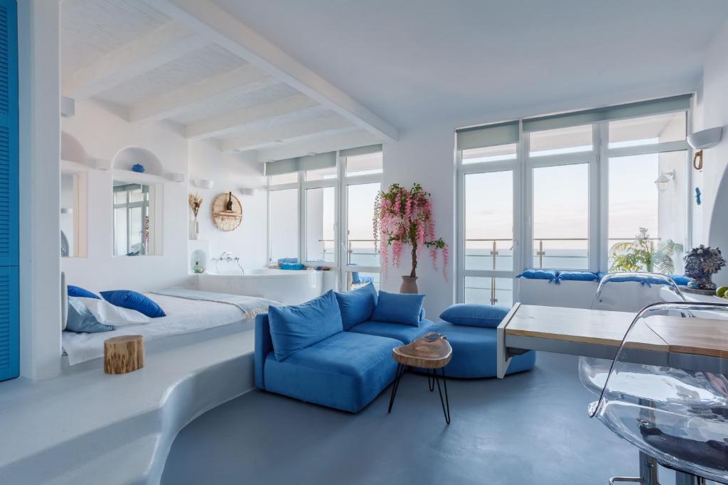 - une chambre blanche dotée d'un mobilier bleu et d'une baignoire dans l'établissement Anna Maria Santorini - Greek Suite & Large sea terrace Arcadia, à Odessa