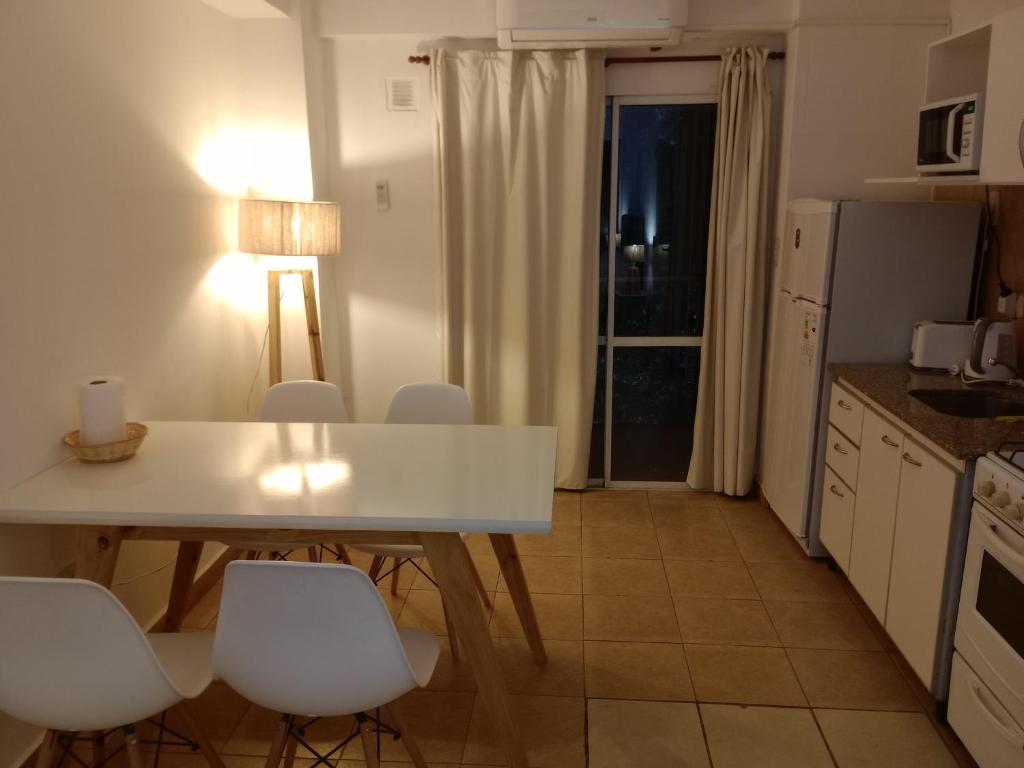 a kitchen with a white table and white chairs at Departamento Haití in San Miguel de Tucumán