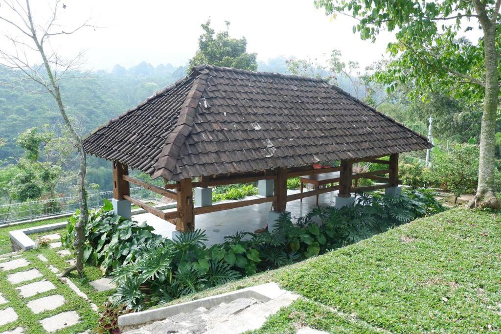 a wooden pavilion with a roof on a hill at Omah Pinaringan in Solo