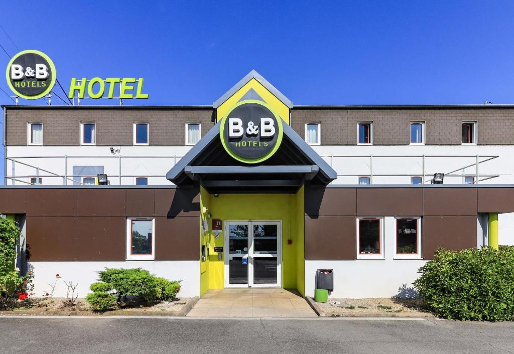un hotel con un cartel en la parte delantera en B&B HOTEL Dijon Nord Zénith en Dijon