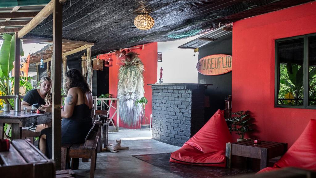 Una donna seduta a un tavolo in un ristorante di House of Lion Hostel a Pantai Cenang