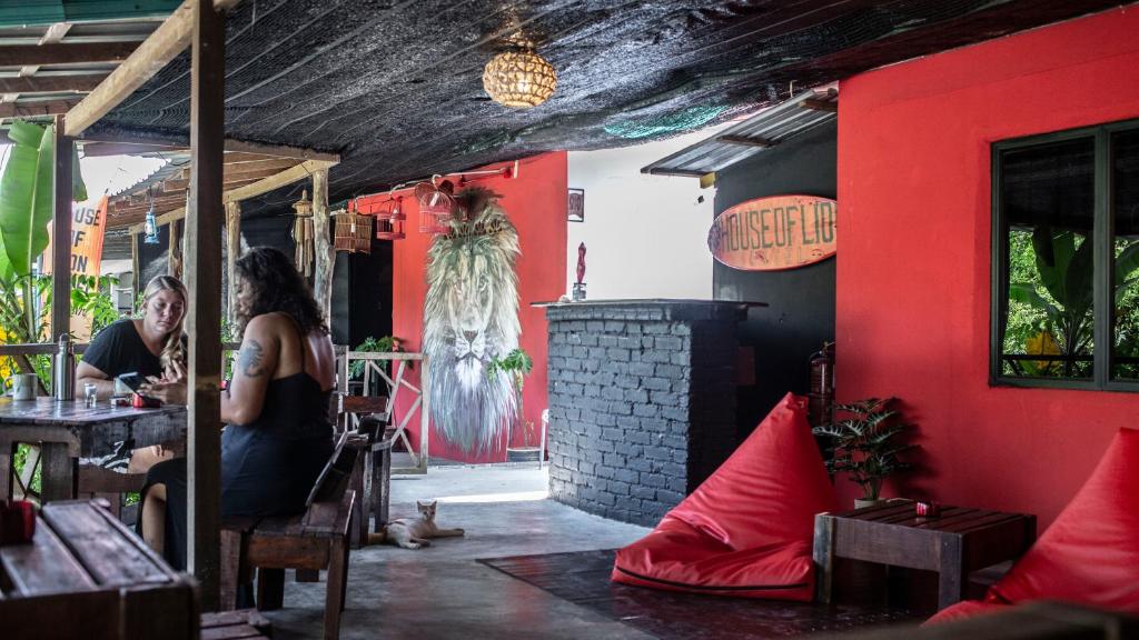 a woman sitting at a table in a restaurant at House of Lion Hostel in Pantai Cenang