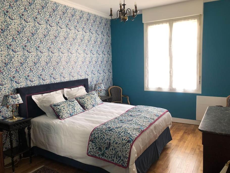 une chambre avec un lit aux murs bleus et une fenêtre dans l'établissement Spacieux T2 rénové à neuf - Hyper centre de Blois, à Blois