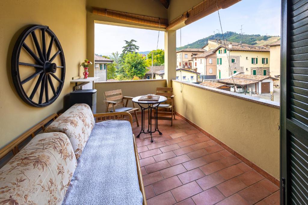 a balcony with a couch and a table and a window at Le Ruote in Vezzano sul Crostolo