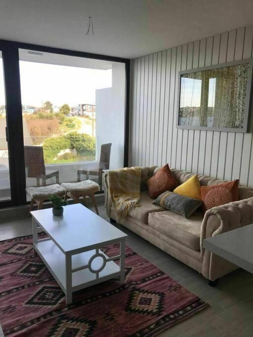 sala de estar con sofá y mesa de centro en Hermoso Depto con vista al lago y volcanes, en Puerto Varas