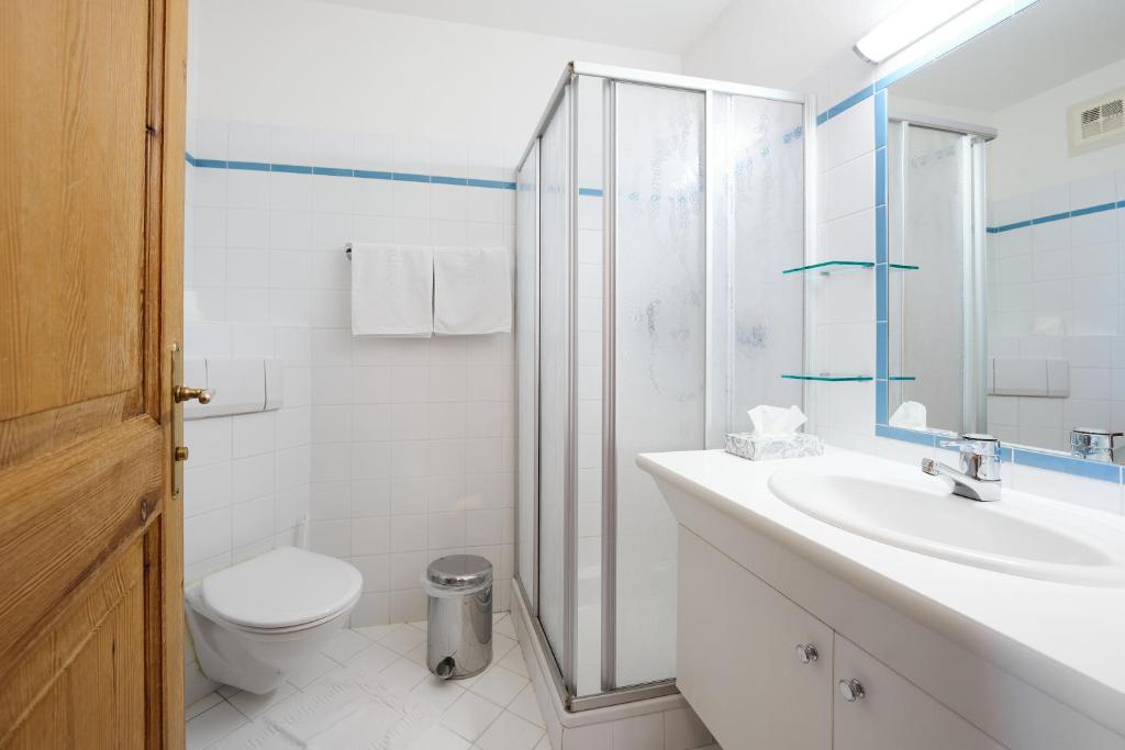 a bathroom with a toilet and a sink and a shower at Alpina Holiday Living Apartments in Obertauern