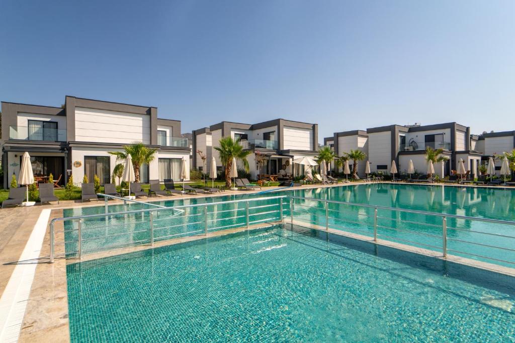 una piscina frente a algunos apartamentos en Seaside Serenity in Bodrum: Luxury Retreat w View, en Turgutreis