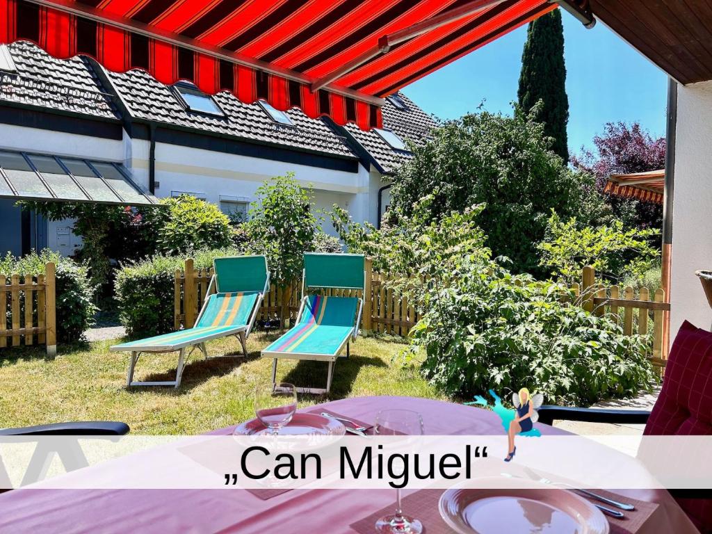 eine Terrasse mit zwei blauen Stühlen und einem Tisch in der Unterkunft Ferienhaus Can Miguel - Urlaubsoase in ruhigem Wohngebiet in Lindau-Bodolz