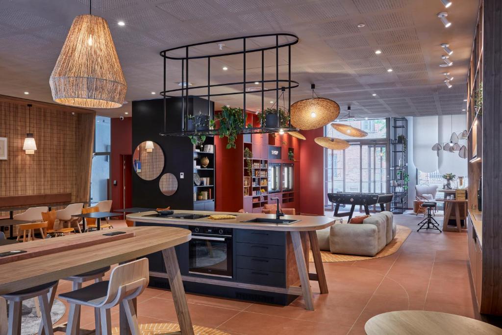 a kitchen with a table and chairs in a room at Aparthotel Adagio Original Toulouse Centre La Grave in Toulouse