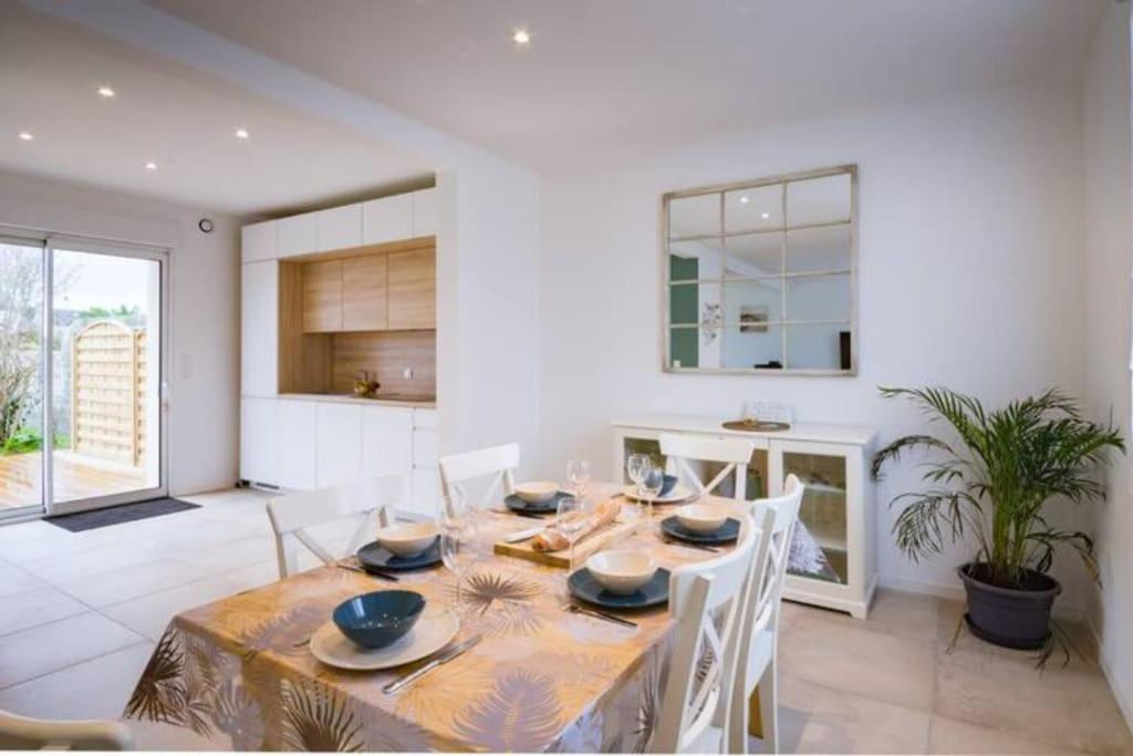 eine Küche und ein Esszimmer mit Tisch und Stühlen in der Unterkunft Ty Glas charmante maison 200 m de la plage in Ploudalmézeau
