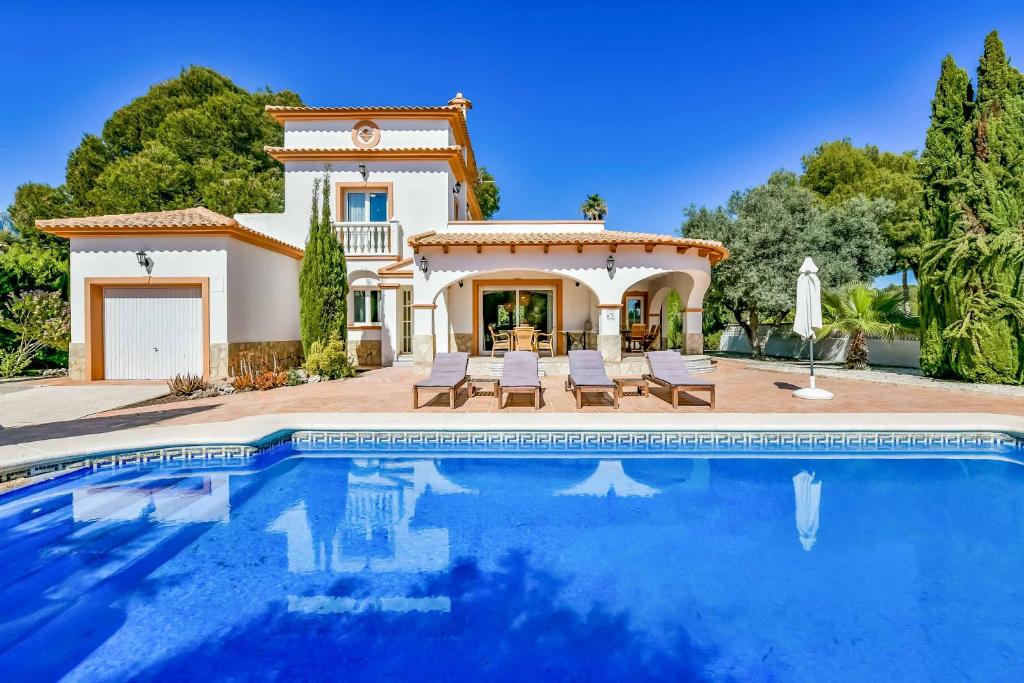 a villa with a swimming pool in front of a house at Villa Angeles Tur in Calpe