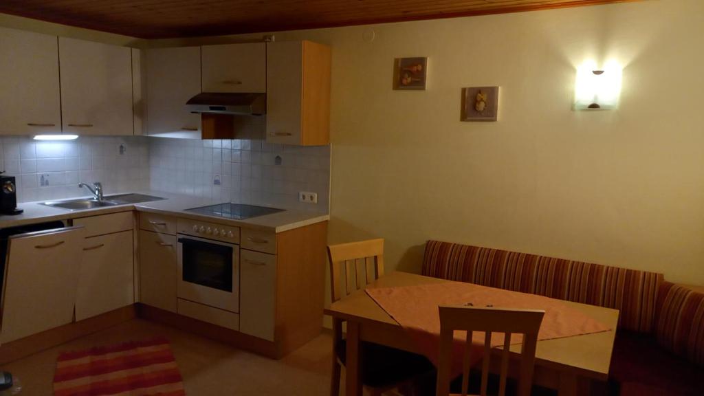 cocina con fregadero, mesa y encimera en Haus Leo, en Bad Mitterndorf