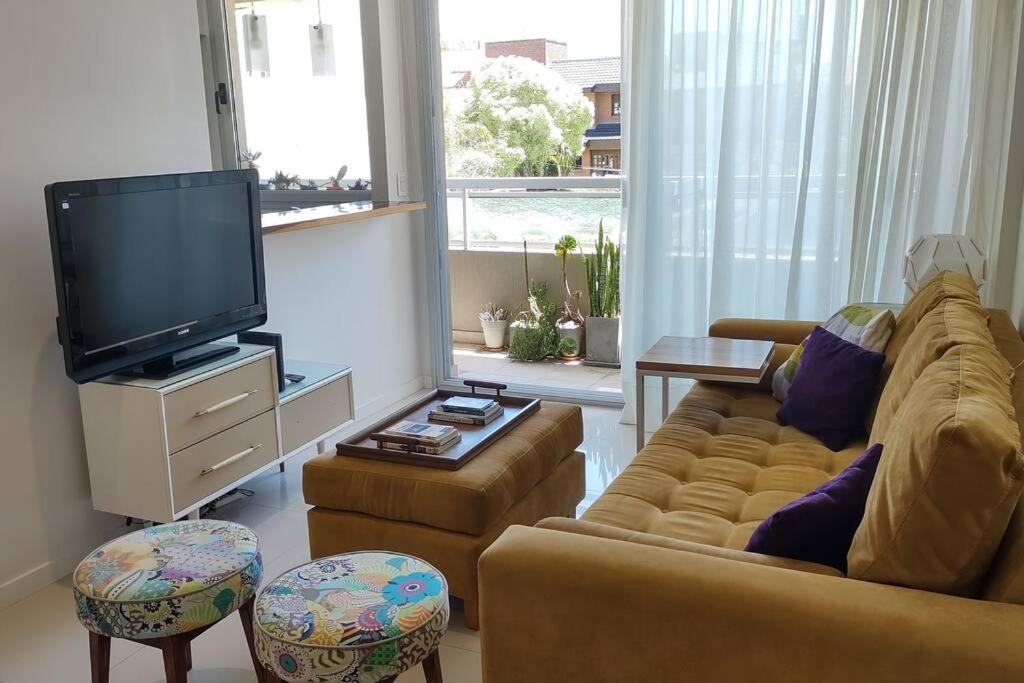 a living room with a couch and a flat screen tv at Zona Güemes. Piscina climatizada. Hermoso 2 amb. in Mar del Plata