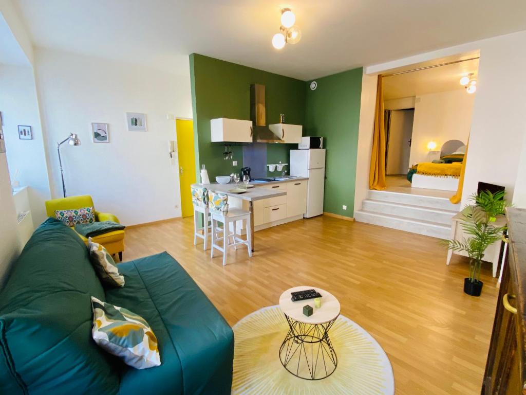Il comprend un salon avec un canapé bleu et une cuisine. dans l'établissement LE SAINT CYRICE, à Rodez
