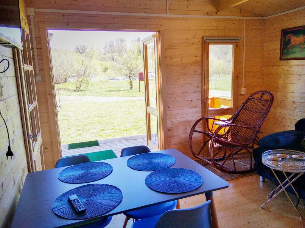 Zimmer mit einem Tisch, Stühlen und einem Fenster in der Unterkunft Domek nad Olszanka in Olszanica