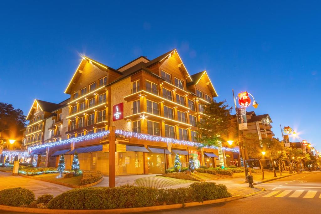 a large building with christmas lights on a street at Hotel Laghetto Stilo Borges Gramado RS in Gramado