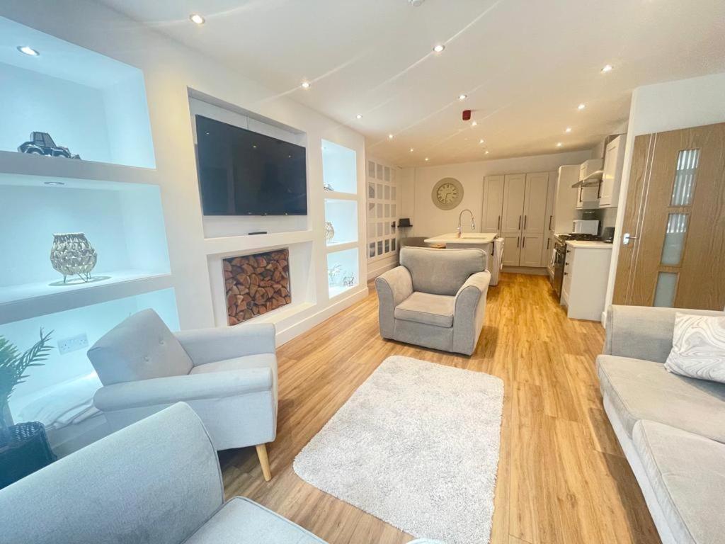 uma sala de estar com mobiliário branco e uma grande televisão em Beach House By Sasco em Blackpool