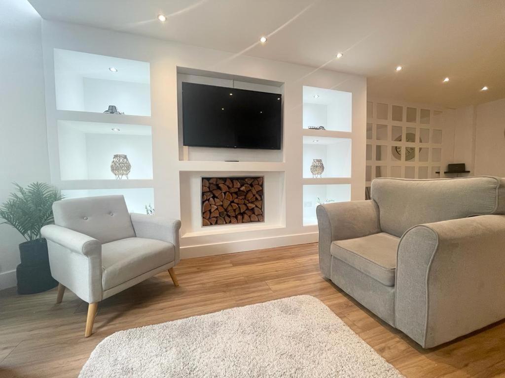 uma sala de estar com 2 cadeiras e uma televisão de ecrã plano em Beach House By Sasco em Blackpool