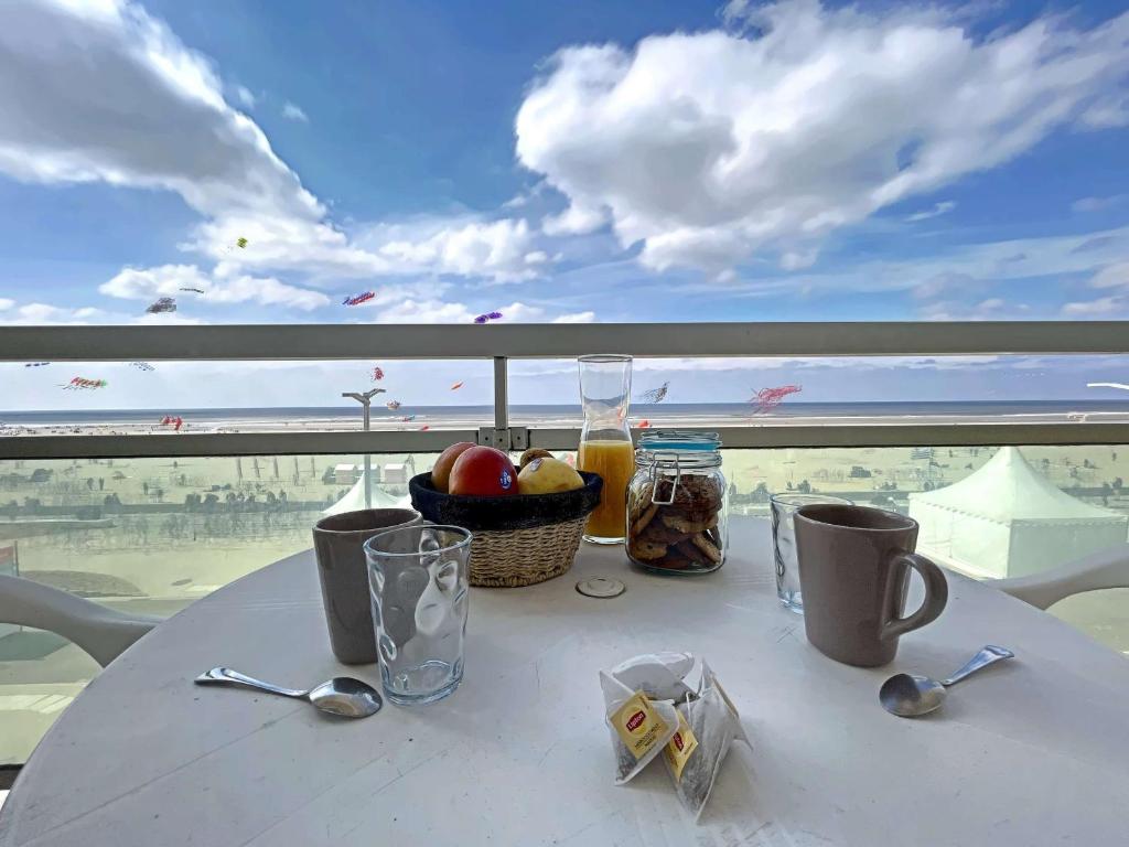 - une table avec un bol de fruits et des boissons sur le balcon dans l'établissement Magnifique T4 avec balcon et garage à Berck-Plage - FR-1-646-48, à Berck-sur-Mer