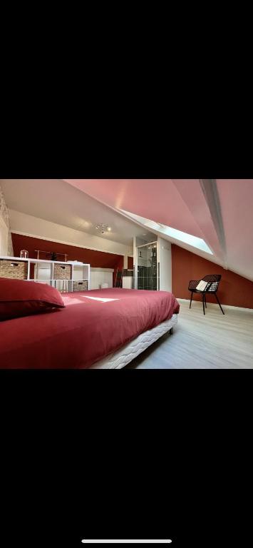 a bedroom with a large red bed and a piano at Gîte l’effet mer 