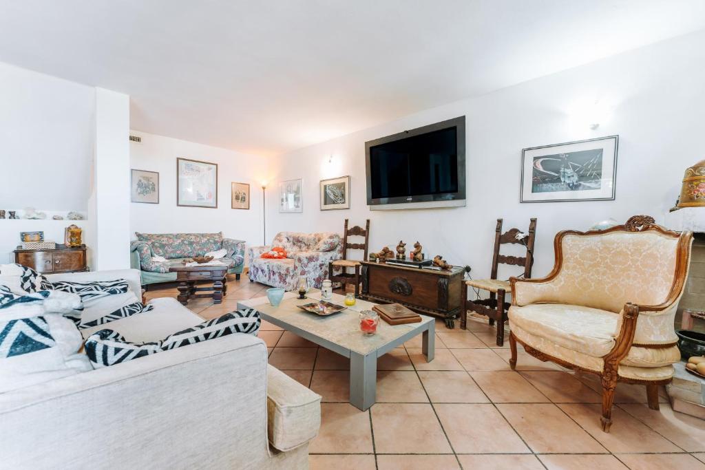 uma sala de estar com sofás e uma televisão em Casa vacanze G e B Sardegna em Capitana