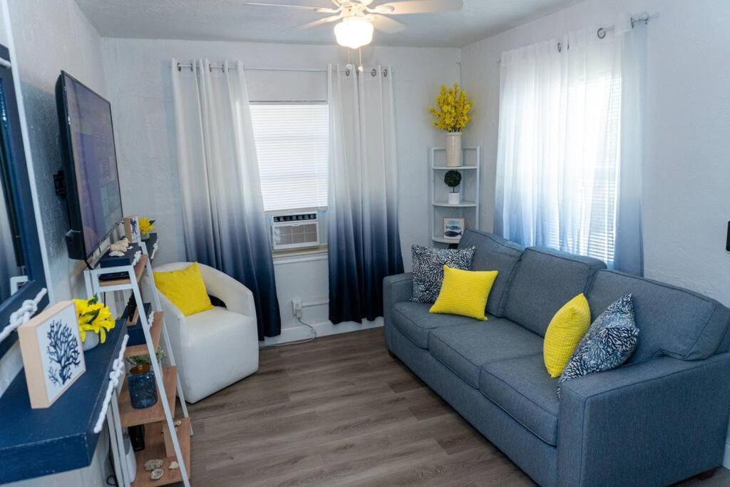 sala de estar con sofá azul y almohadas amarillas en Beachside Bliss Cozy 2 BD Retreat Pompano Beach, en Pompano Beach