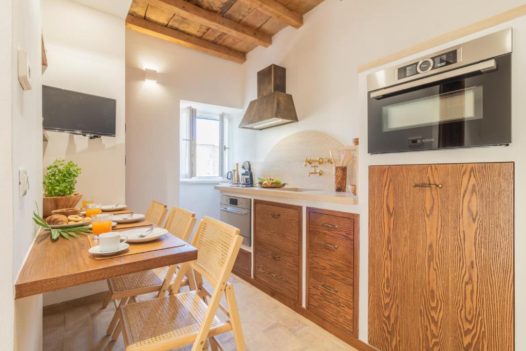 een keuken met een houten tafel en een eetkamer bij La Dimora del Buttero in Farnese