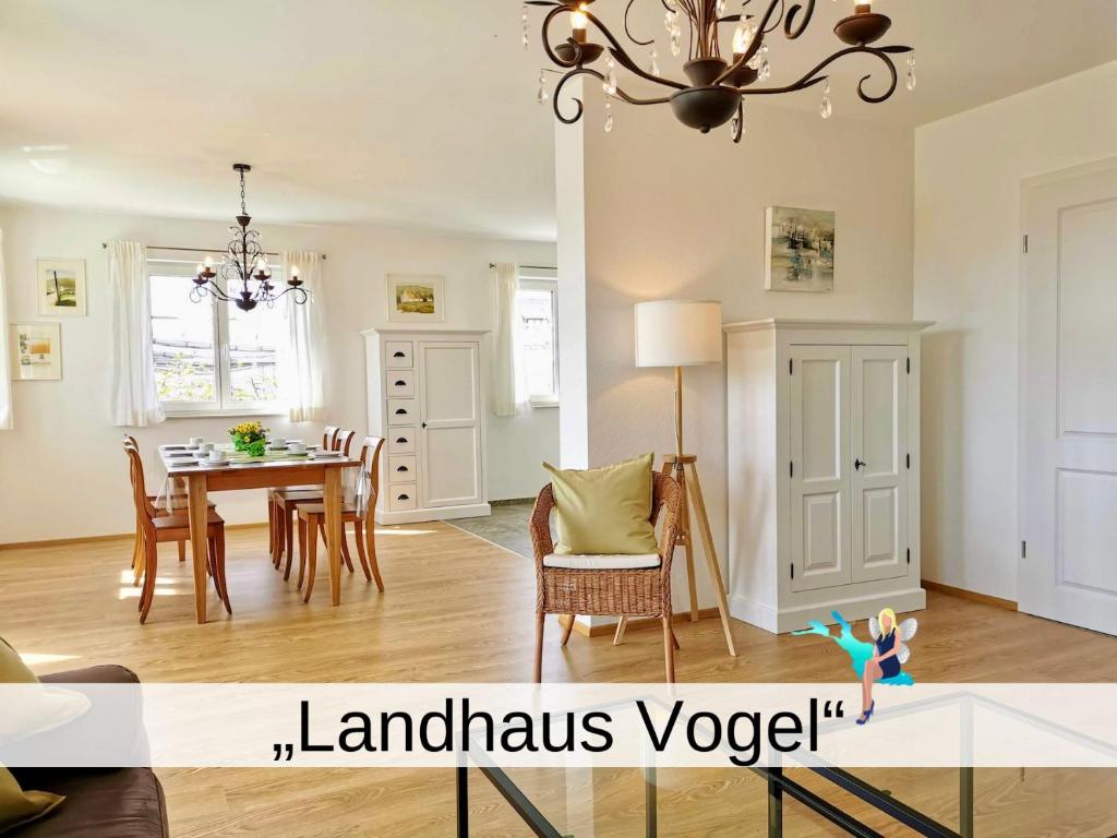 uma sala de jantar e sala de estar com mesa de jantar em Landhaus Vogel - helle und lichtdurchflutete Maisonette-Ferienwohnung em Wasserburg