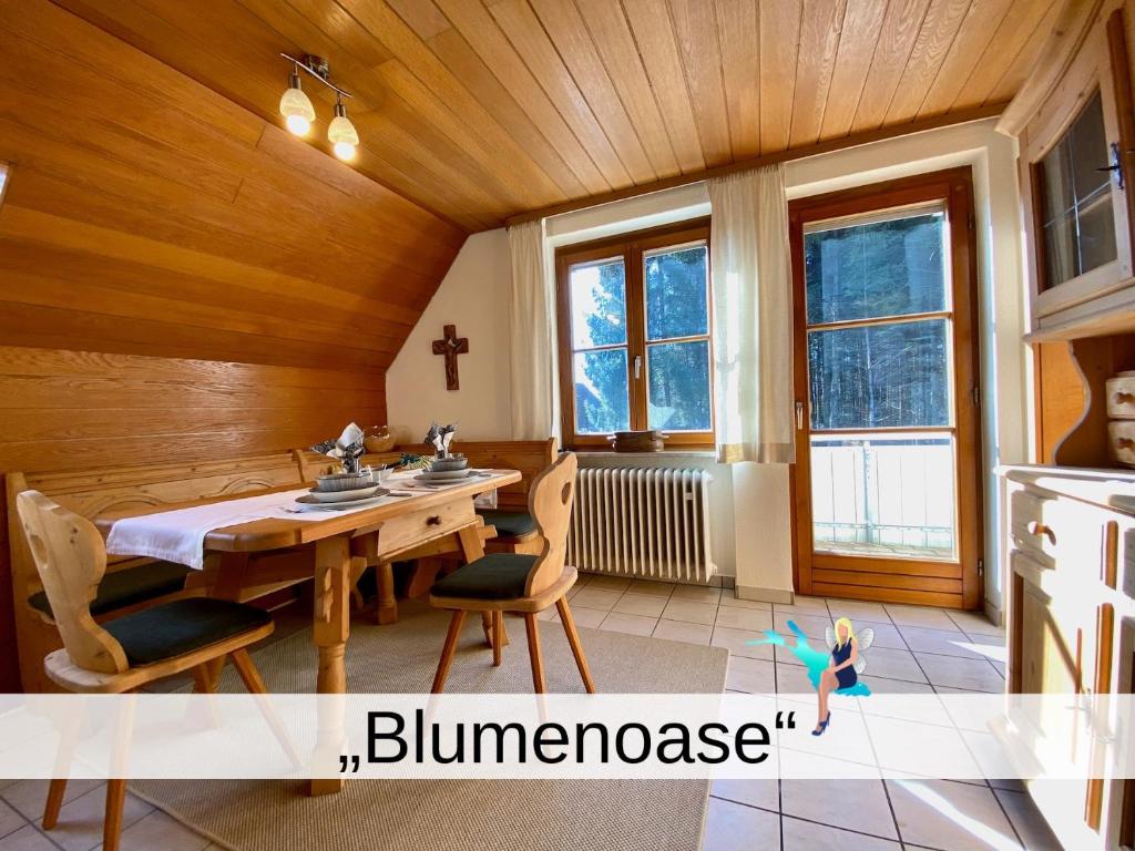 comedor con techo de madera, mesa y sillas en Ferienwohnung Blumenoase - gemütliche Ferienwohnung zwischen Allgäu und Bodensee, en Sigmarszell