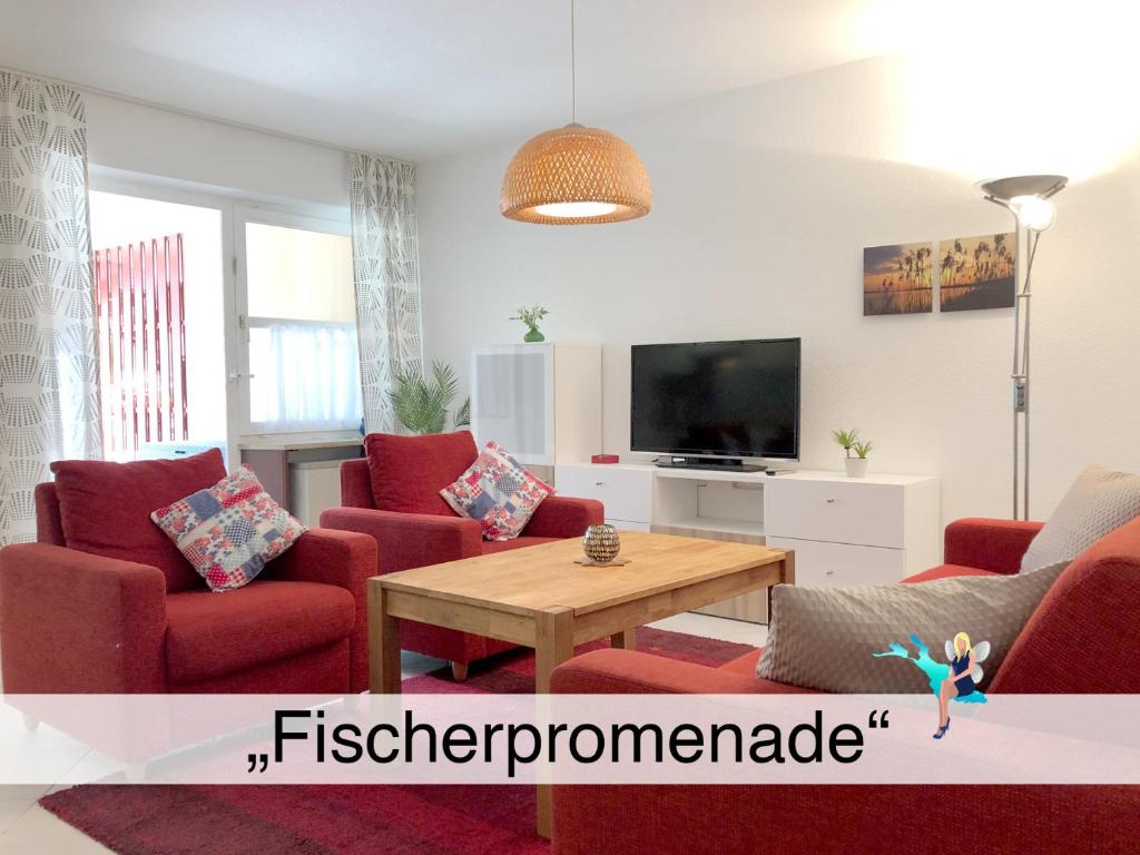 a living room with red chairs and a tv at Ferienwohnung Fischerpromenade in Kressbronn am Bodensee