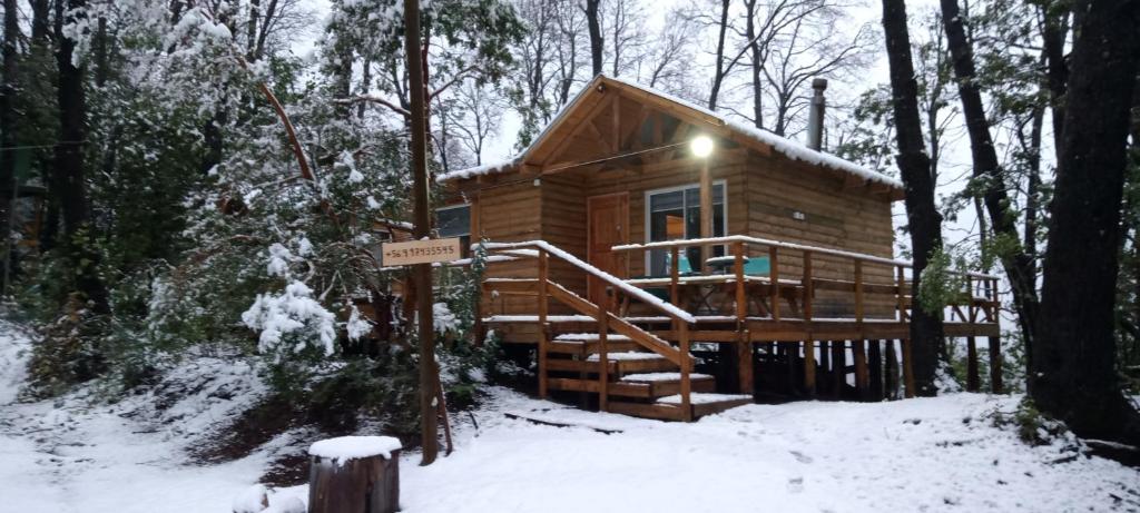 uma cabana de madeira na floresta na neve em Cabañas el Mirador em Recinto