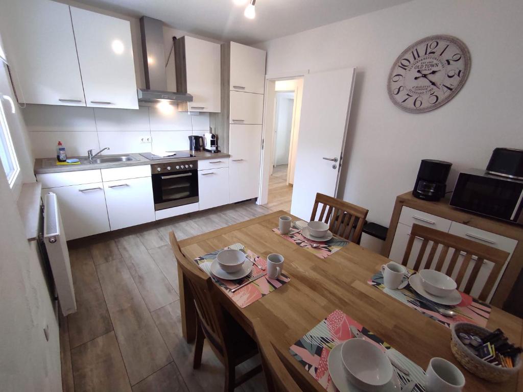 a kitchen with a table and a clock on the wall at Ferienwohnung am Rathaus in Landstuhl