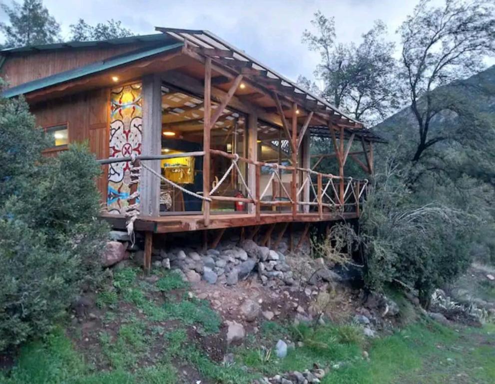 a wooden house with a deck on a hill at Arte Vitral Lodge - 4camas- aislada- terrazas -vista - piscina-sauna in Guayacán