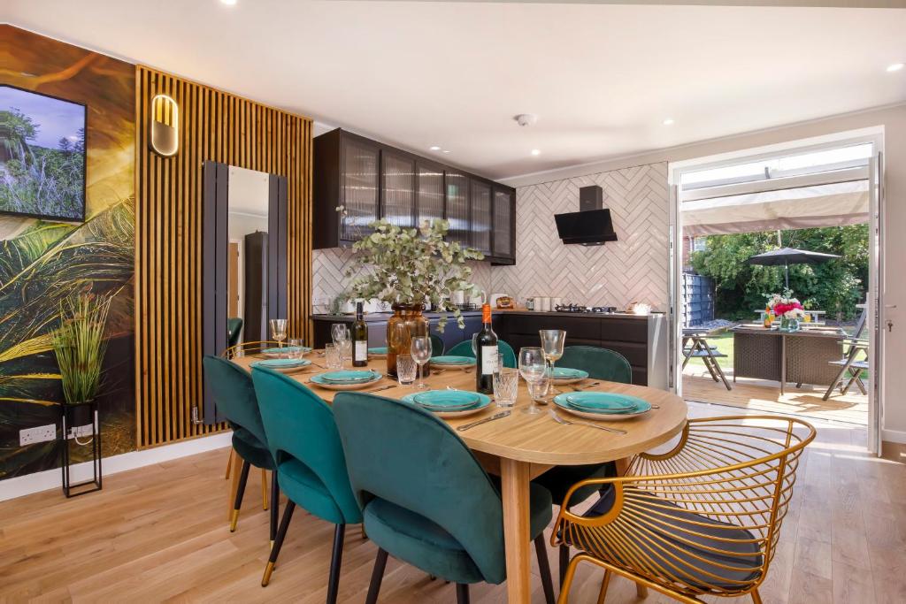 a dining room with a wooden table and green chairs at The Dodsworth modern 4 bedroom house, sleeps 8 in York