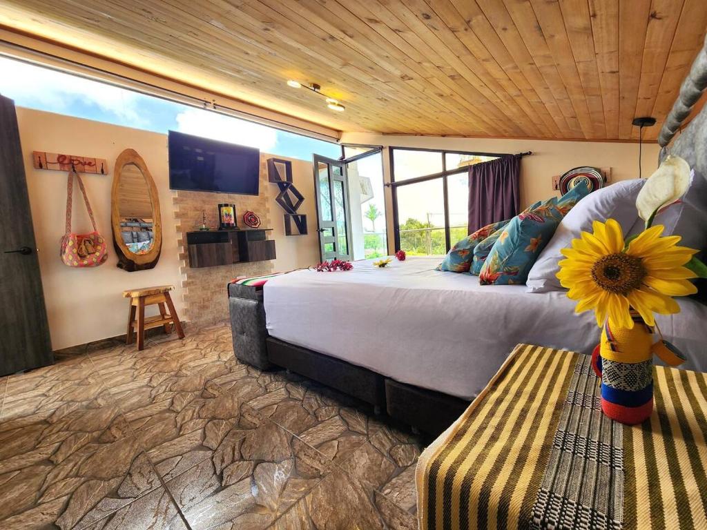 a bedroom with a large bed with a flower on a bench at Vacation Home Villa Namaste Colombia in Ulloa