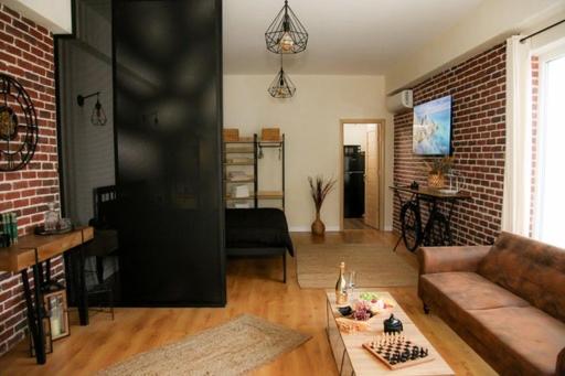 a living room with a couch and a brick wall at Studio Zeus in Neptun